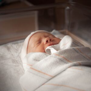 baby in white and pink blanket
